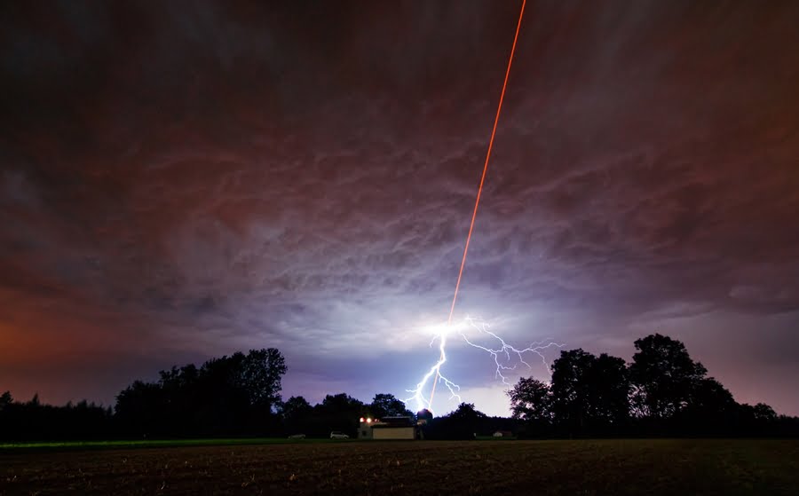 As ESO tested the new Wendelstein laser guide star unit by shooting a powerful laser beam into the atmosphere, one of the region’s intense summer thunderstorms was approaching — a very visual demonstration of why ESO’s telescopes are in Chile, and not in Germany. Heavy grey clouds threw down bolts of lightning as Martin Kornmesser, visual artist for the ESO outreach department, took timelapse photographs of the test for ESOcast 34. With purely coincidental timing this photograph was snapped just as lightning flashed, resulting in a breathtaking image that looks like a scene from a science fiction movie. Although the storm was still far from the observatory, the lightning appears to clash with the laser beam in the sky. Laser guide stars are artificial stars created 90 kilometres up in the Earth’s atmosphere using a laser beam. Measurements of this artificial star can be used to correct for the blurring effect of the atmosphere in astronomical observations — a technique known as adaptive optics. The Wendelstein laser guide star unit is a new design, combining the laser with the small telescope used to launch it in a single modular unit, which can then be placed onto larger telescopes. The laser in this photograph is a powerful one, with a 20-watt beam, but the power in a bolt of lightning peaks at a trillion (one million million) watts, albeit for just a fraction of a second! Shortly after this picture was taken the storm reached the observatory, forcing operations to close for the night. While we may have the ability to harness advanced technology for devices such as laser guide stars, we are still subject to the forces of nature, not least among them the weather! Links Read more about ESO’s Wendelstein laser guide star unit at: http://www.eso.org/public/announcements/ann11039/  