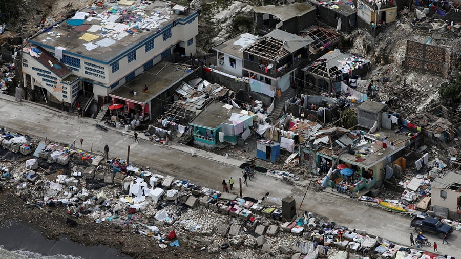 People walk next to destroyed houses after Hurricane Matthew hit Jeremie, Haiti, October 6, 2016. REUTERS/Carlos Garcia Rawlins