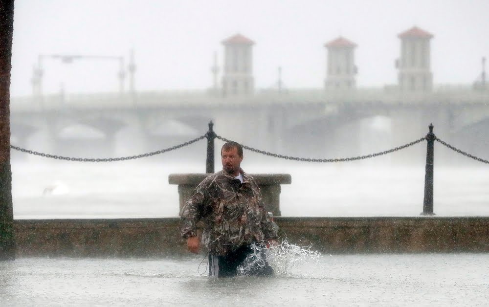 A man wades through flood water as he check out damage from Hurricane Matthew Friday, Oct. 7, 2016, in St. Augustine , Fla.  (AP Photo/John Bazemore)